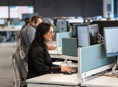 Woman working at a desk typing on computer