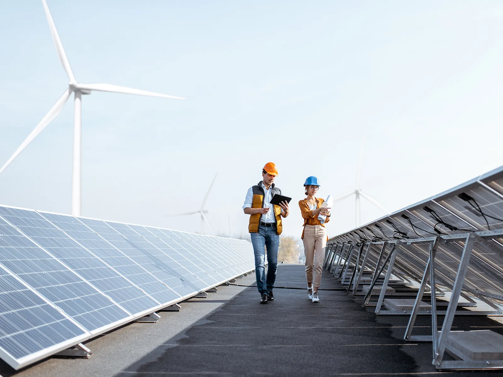 Man and woman walking in-between solar panels taking notes