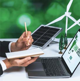Man at computer taking notes with pen and notebook